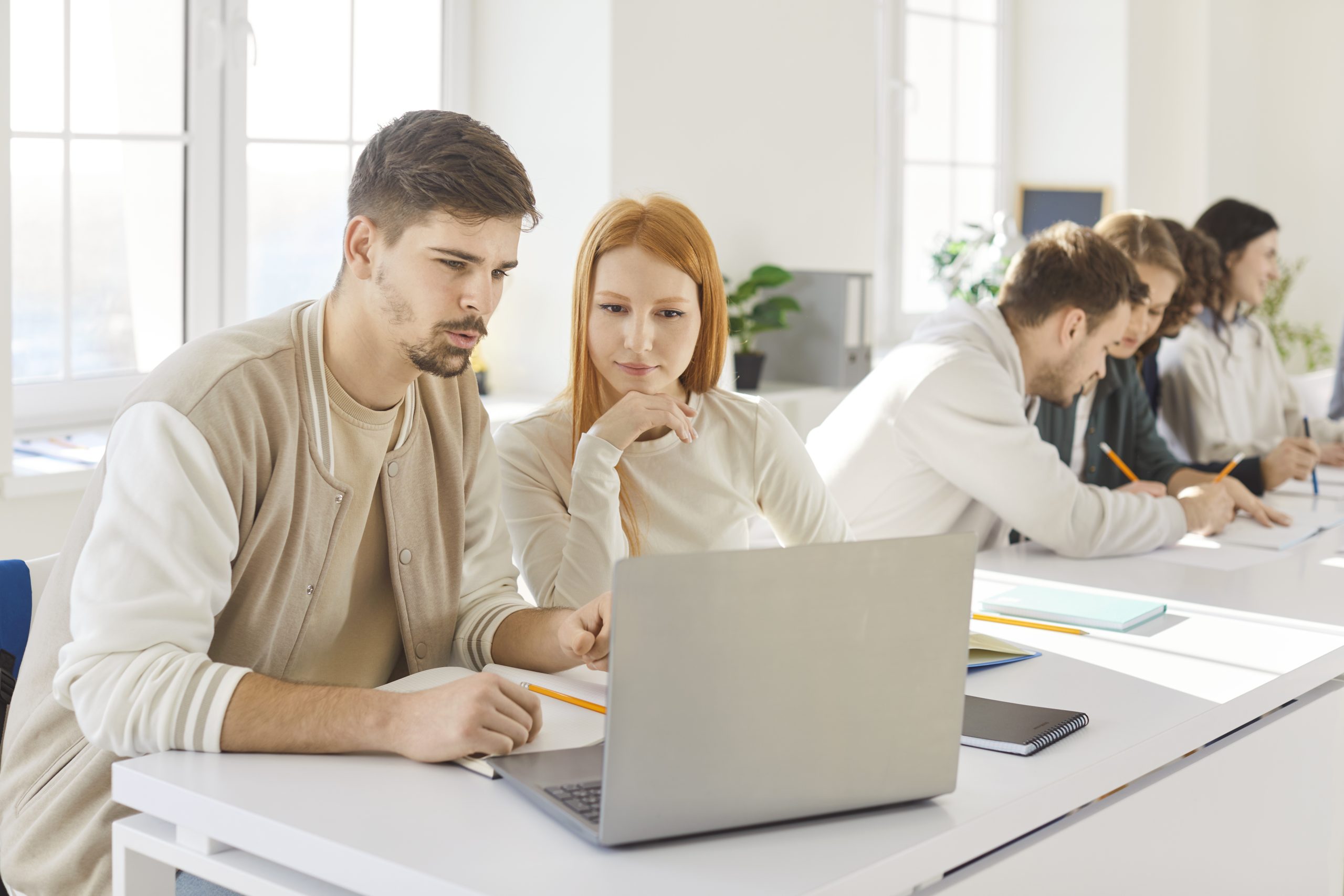 Team of young college friends students working online in pairs doing study project in university