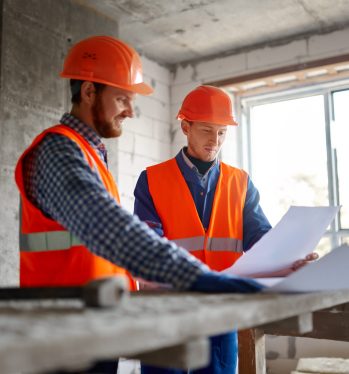 Builder worker with blueprint in indoor apartment